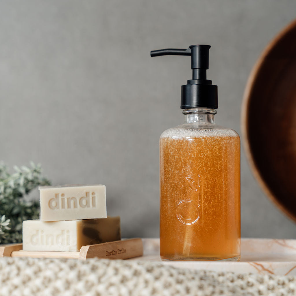 glass dindi bottle with liquid and soaps