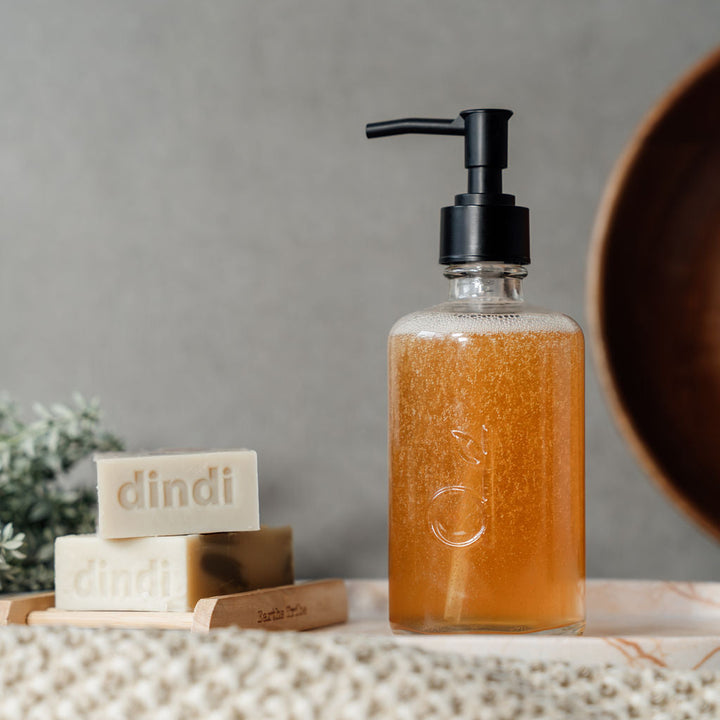 glass dindi bottle with liquid and soaps