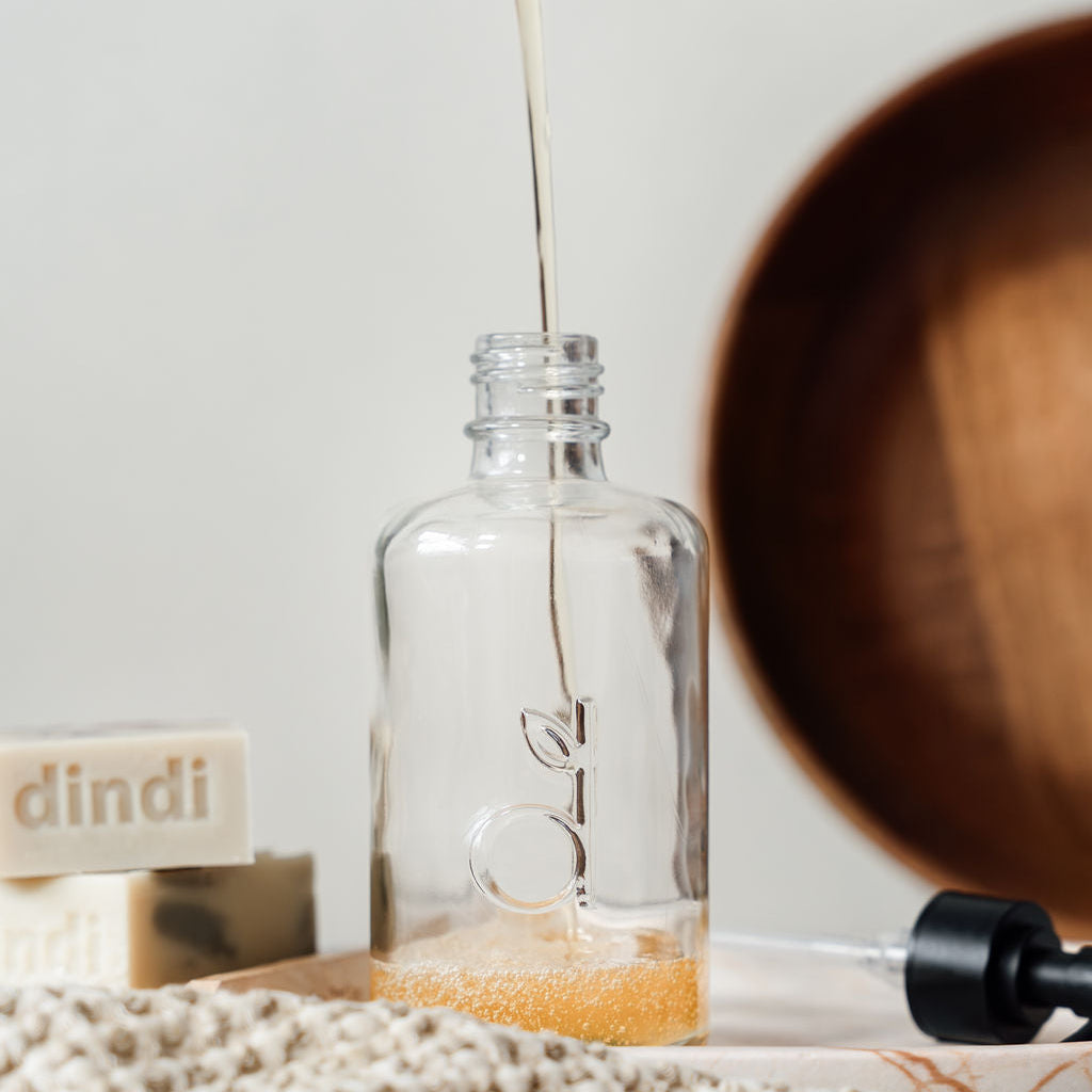 glass dindi bottle being refilled